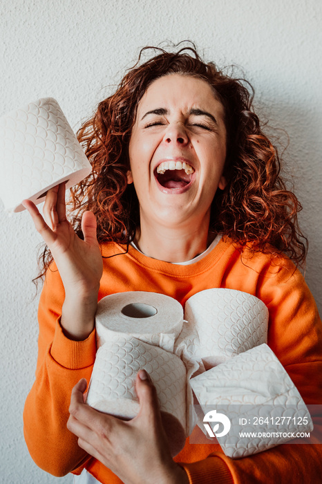 .Young woman hoarding a lot of toilet paper at home. Madness caused by the coronavirus health crisis