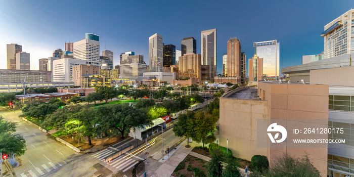 Aerial view downtown Houston illuminated at twilight with green city park and modern skylines light.