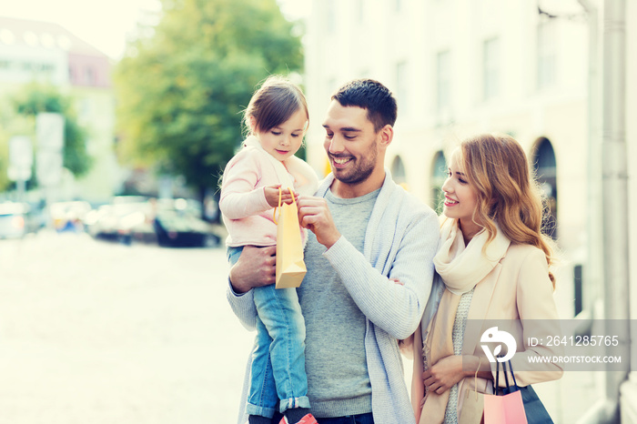 happy family with child and shopping bags in city