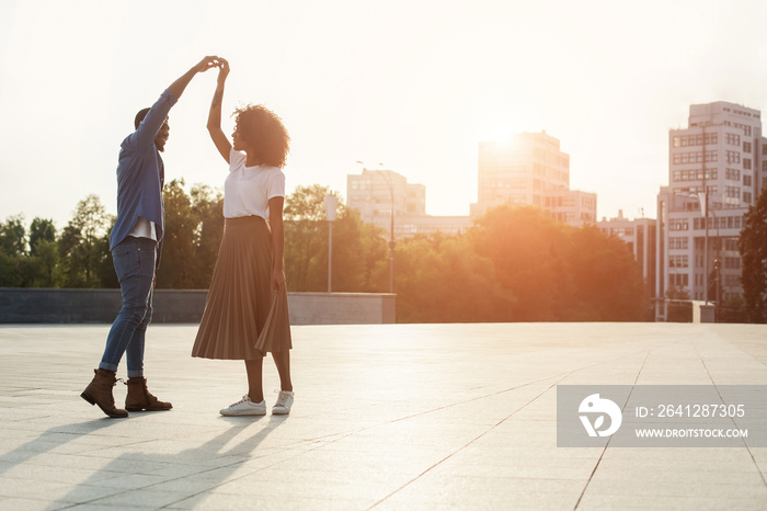 Romantic couple dancing at sunset and having fun, copy space