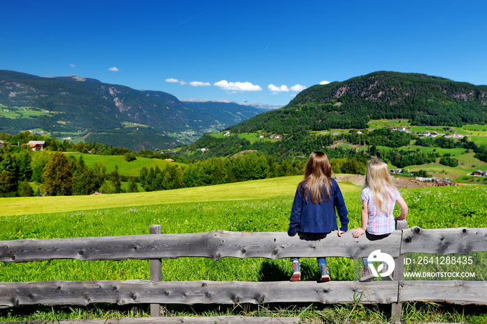 两个可爱的小姐妹在欣赏南蒂罗尔多洛米蒂山脉的美丽风景。