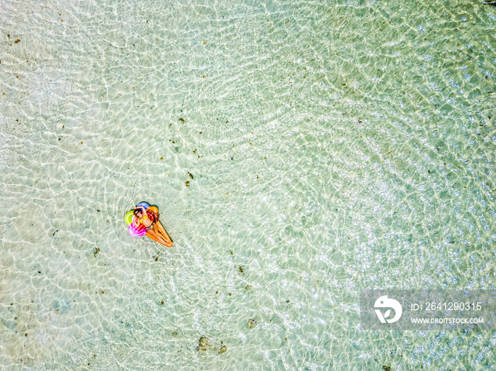 Aerial view of people in summer holiday vacation with beautiful girl on coloured trendy lilo relaxin