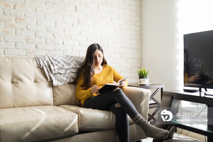 Hispanic Woman Relaxing In Living Room