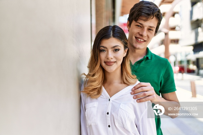 Young caucasian couple smiling happy and hugging standing at the city.