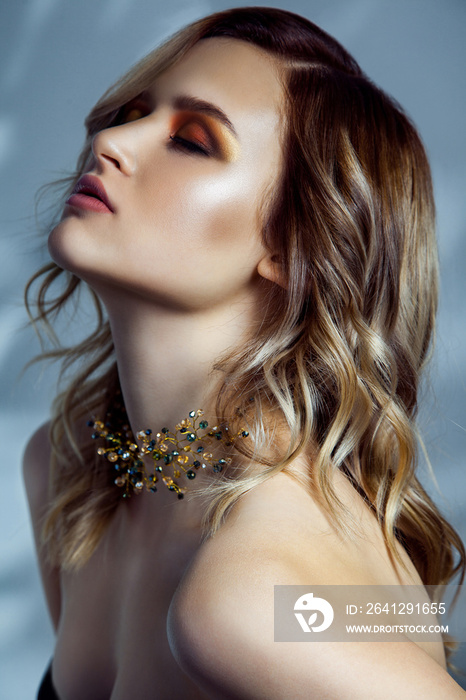 Beauty portrait of beautiful fashion model with makeup, colored wavy hairstyle and accessories on he