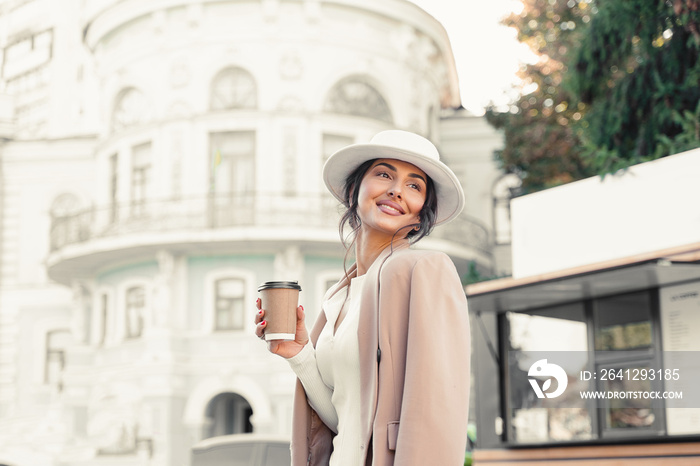 Smiling attractive woman with cup of coffee near coffe shop. Business lady have a break.