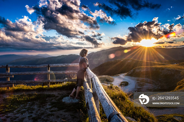 女孩倚在围栏上，在一个宁静的地方，P山观看美丽的日落