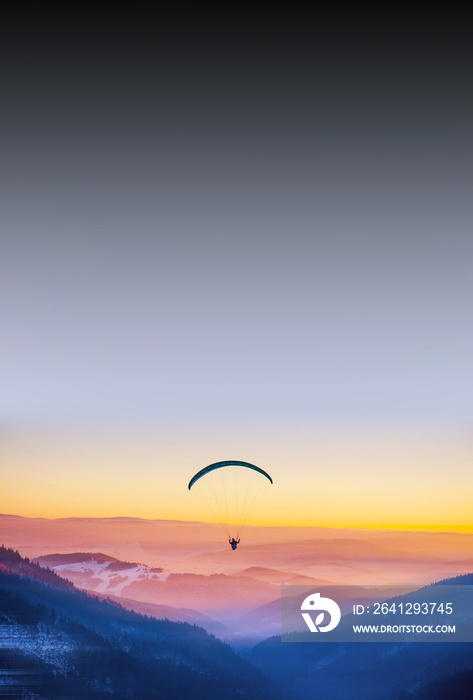 美丽的黄昏中的Paraglide。背景是山脉。