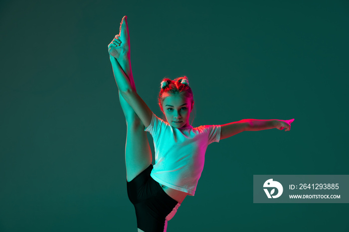 灵活的小女孩，艺术体操艺术家培训隔离在neo的绿色工作室背景下
