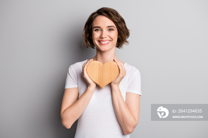 Photo of young beautiful cheerful romantic young lady hold heart love gift present isolated over gre