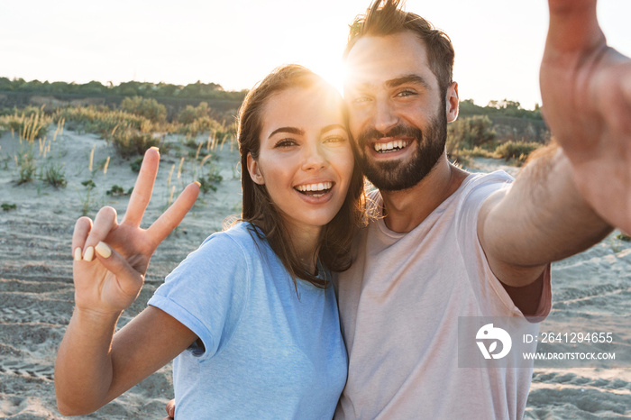 Beautiful young smiling couple spending time at the beach