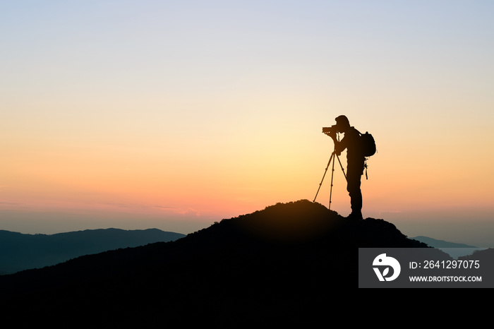 photographer on top of mountain at sunset background