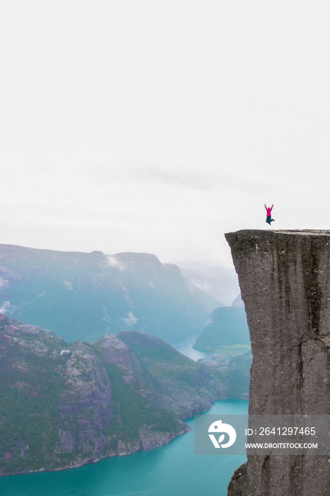 雨中普雷克斯托伦或普尔皮特岩上的女孩。挪威。