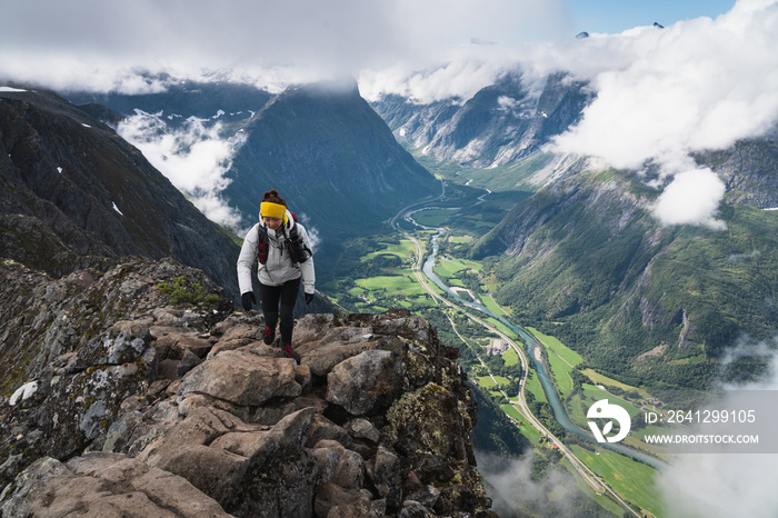 亚洲女性徒步旅行者和旅行者在挪威罗姆斯代尔根徒步小径的狭窄山脊上行走，扫描
