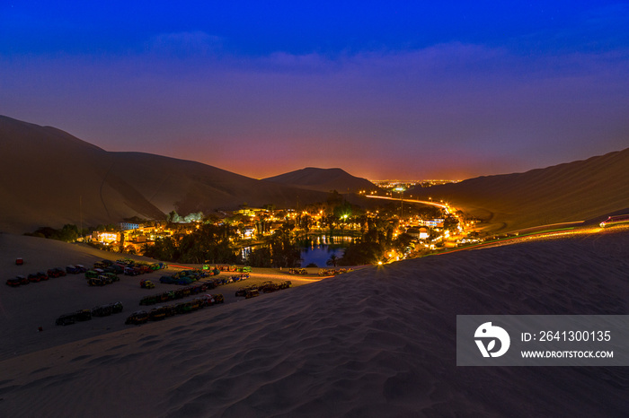 The night desert view of Huacachina oasis, Ica, Peru .