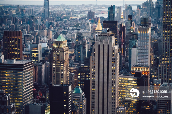 Aerial view of various high Manhattan skyscrapers buildings with lighted windows located in New York