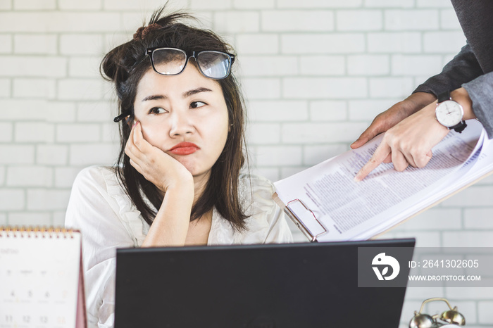 tired and bored female Asian employee ignore annoying boss at office desk