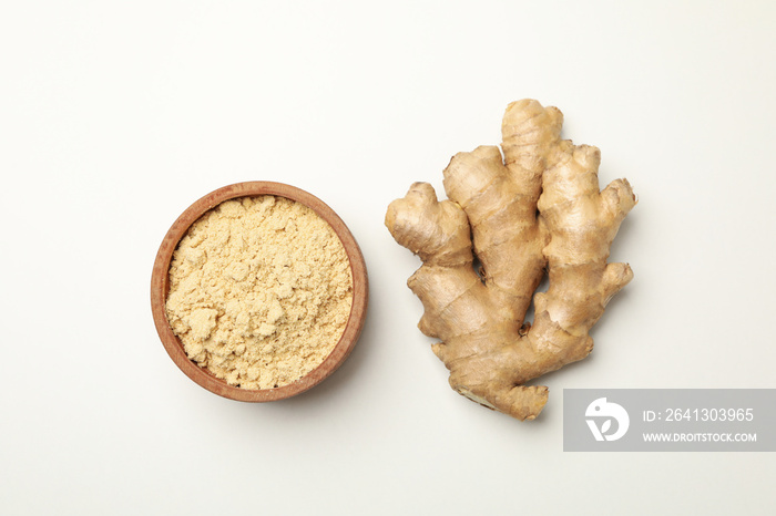 Ginger and bowl with ginger powder on white background