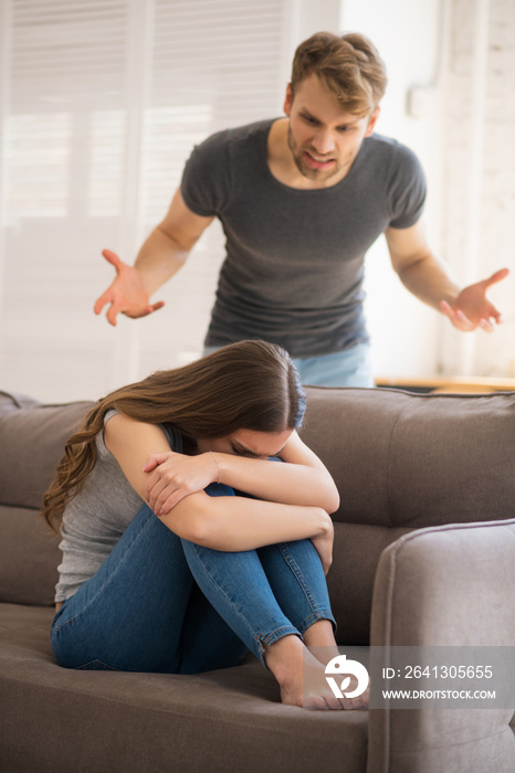 Young bearded man shouting on his upset wife and blaming her