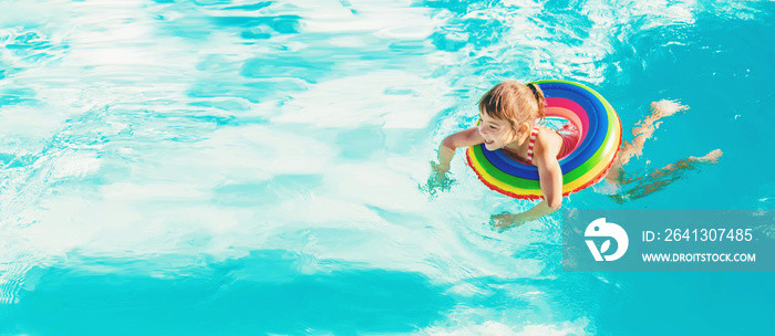 一个孩子带着救生衣在游泳池里游泳。有选择地集中注意力。