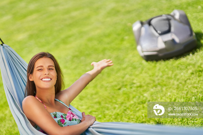 Pretty woman Relaxing In Hammock with automower in background