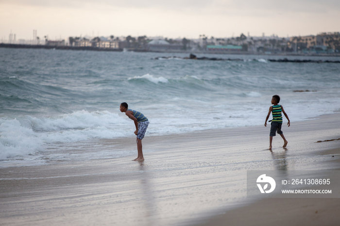 Two boys playing on Huntington Beach, California, USA