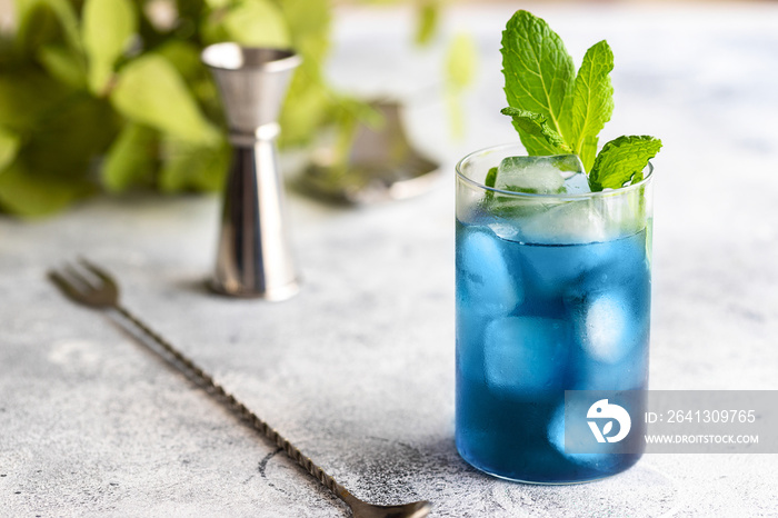 Blue lagoon, Tropical cocktail served with ice cubes decorated with mint. Refreshing alcohol drink f