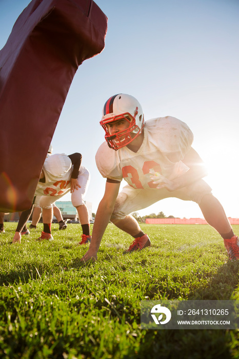 Teenage football player (14-15, 16-17) practicing with team mates