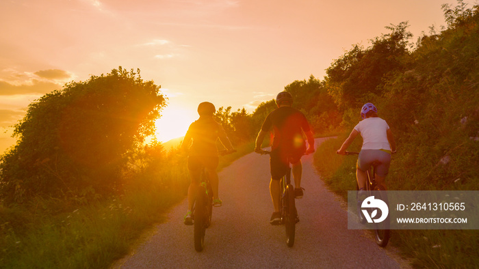 LENS FLARE: Fit friends enjoy a bicycle journey on an idyllic summer evening.