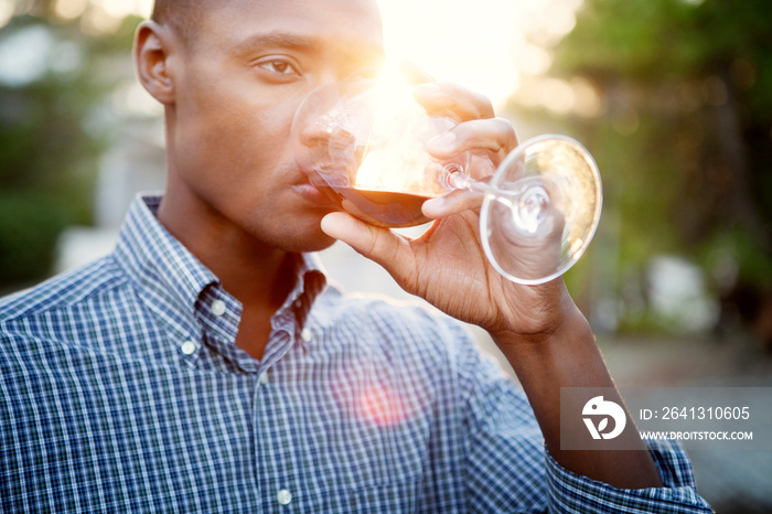 Man looking away while drinking red wine