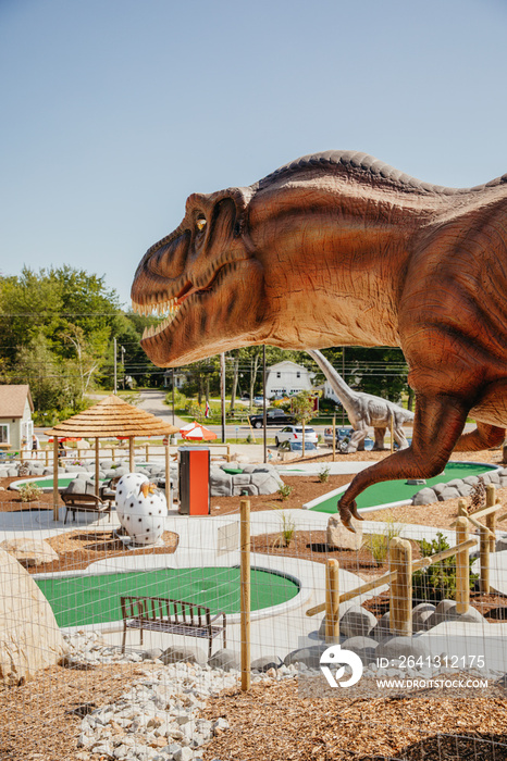 Artificial dinosaur in miniature golf course against clear sky