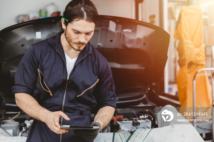 Garage technician worker using tablet computer advance technology for service checking and tuning ca