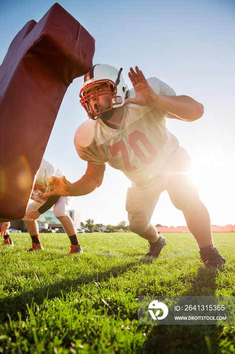 Teenage football player (14-15, 16-17) practicing with team mates