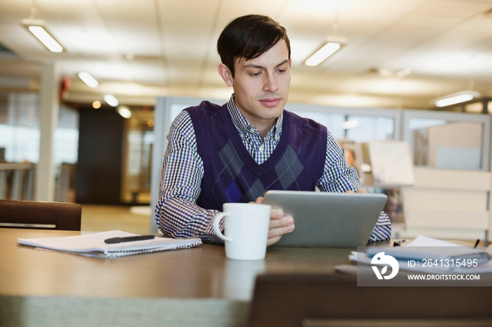 Businessman using digital tablet at office desk