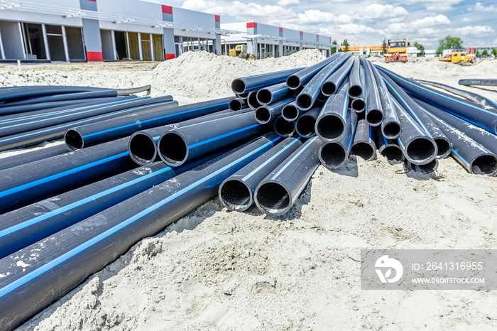 Distributed plastic pipes are stacked, piled temporarily at building site