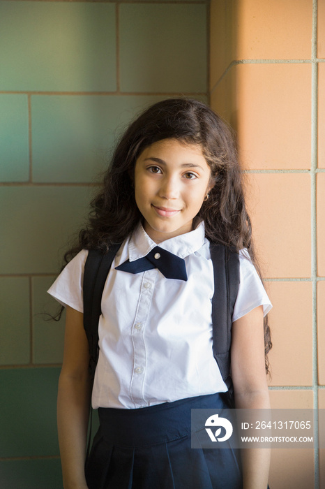 Portrait of schoolgirl (8-9) standing in school corridor