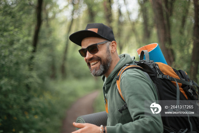 A young guy with a backpack in the cap, traveller in the woods, Hiking, Forest, Journey