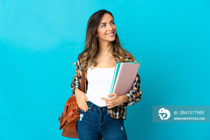 Young student woman isolated on blue background thinking an idea while looking up