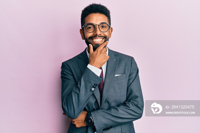 Handsome hispanic business man with beard wearing business suit and tie looking confident at the cam