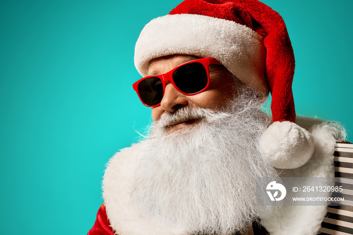 戴着红色太阳镜的圣诞老人在工作室微笑摆姿势