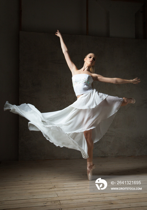 美丽的芭蕾舞演员穿着白色服装，挥舞着裙子跳舞