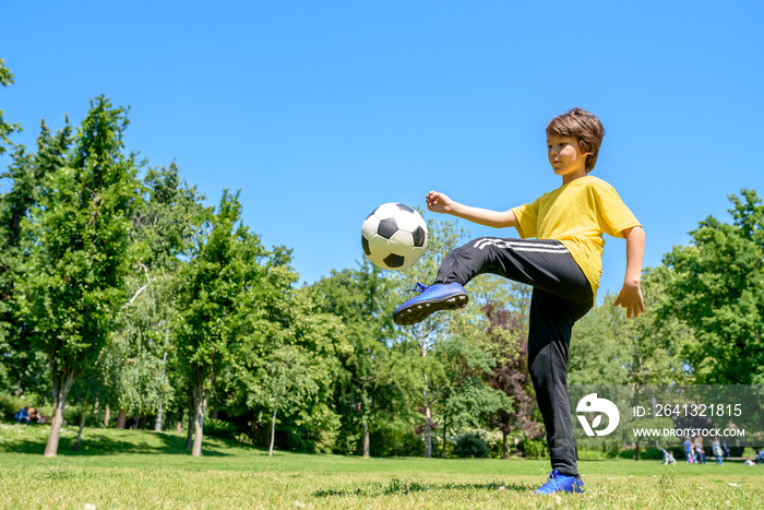 穿着运动服的可爱男孩在公园的球场上踢足球。足球儿童训练