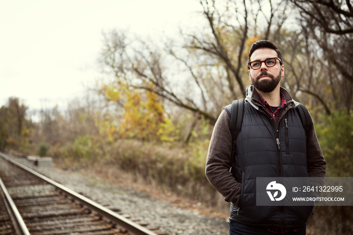 Mid-adult man standing on railroad tracks