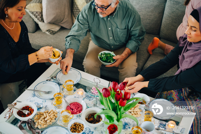 High angle view of family having food while sitting in living room at home