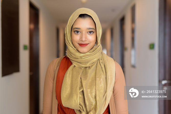 Young beautiful Indian Muslim woman wearing hijab in the corridor