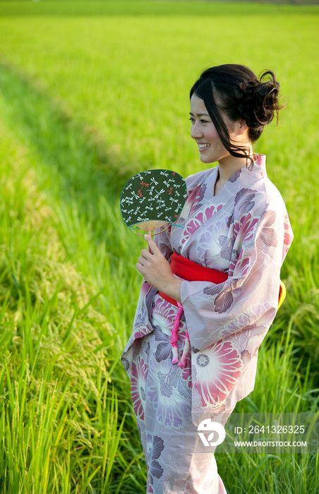 Portrait of young Japanese woman in field wearing kimono