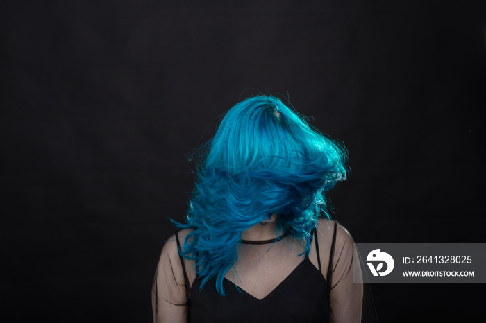 people, fashion and hair concept - close-up portrait of young woman in black dress with blue hair on