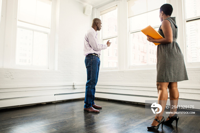 Female real estate agent showing apartment to man