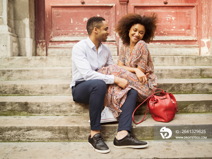 Smiling couple sitting on steps