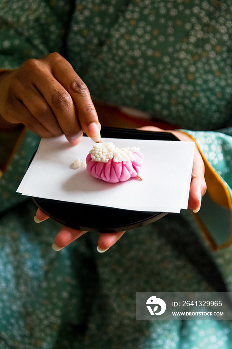 黑女人用木牙签切Wagashi，日本传统糖果